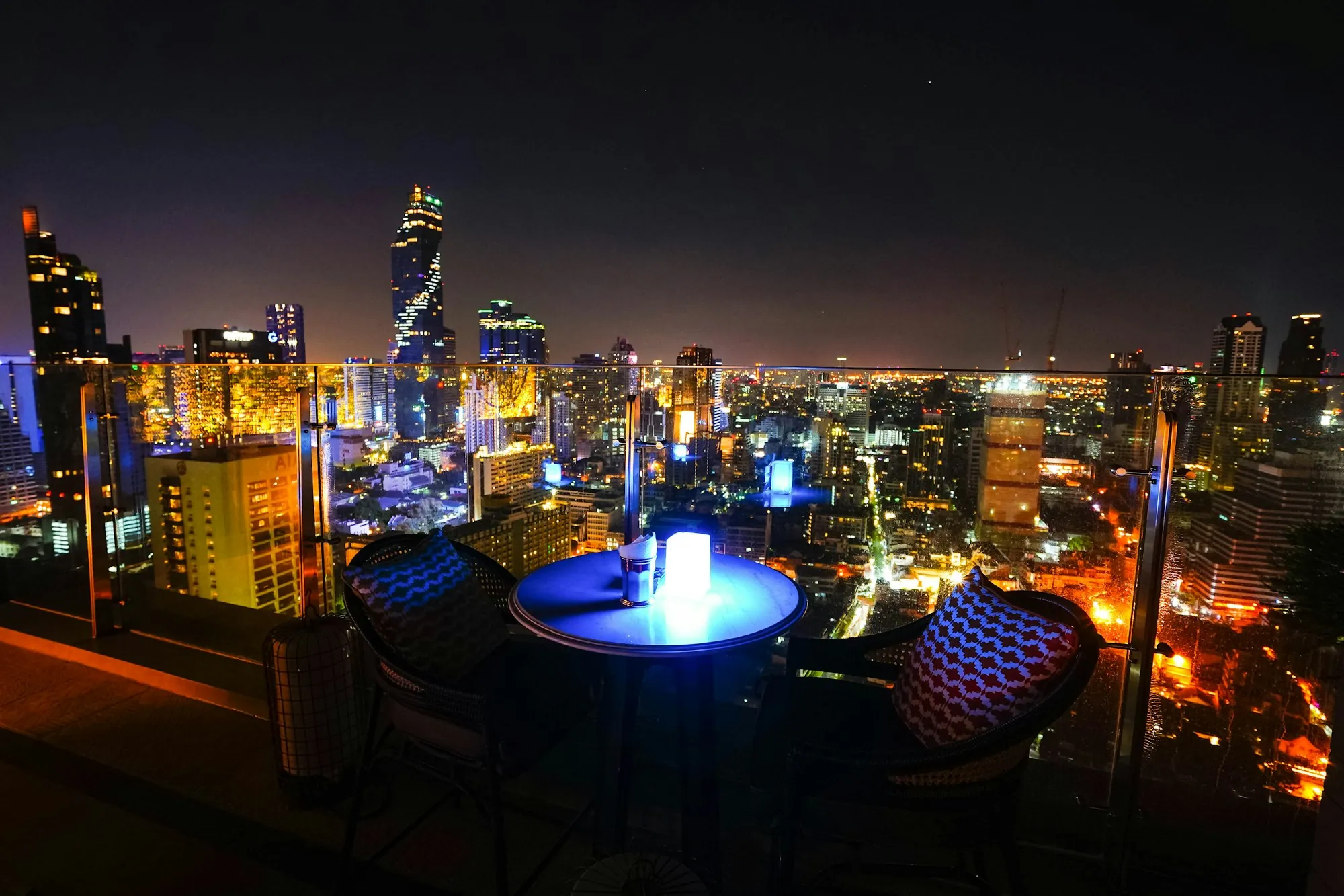 Terrasse en hauteur la nuit, face à la ville illuminée